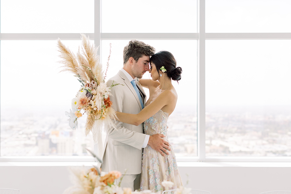  bride in a modern a line gown with a tulle skirt and the groom in a navy shawl lapel tuxedo 