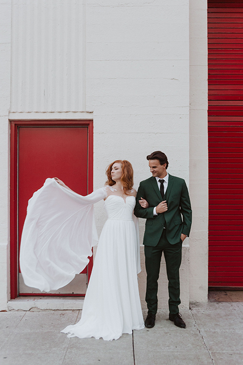  bride in a white ballgown and the groom in a green suit with a chocolate long tie