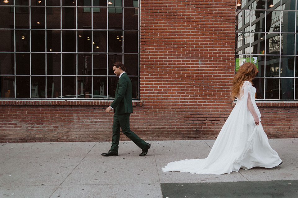  bride in a white ballgown and the groom in a green suit with a chocolate long tie 