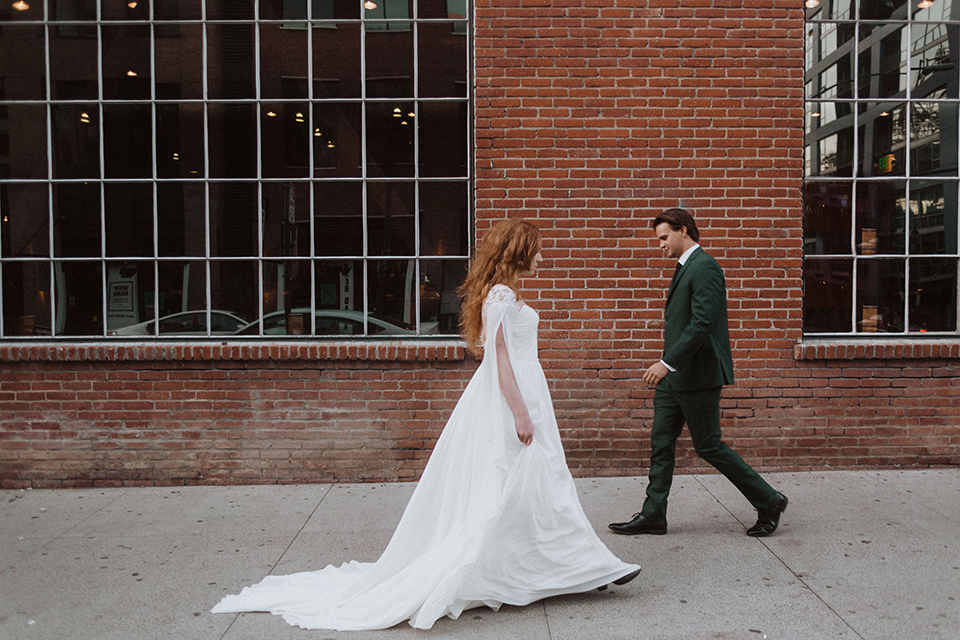  bride in a white ballgown and the groom in a green suit with a chocolate long tie 