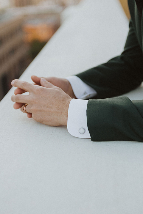  bride in a white ballgown and the groom in a green suit with a chocolate long tie 