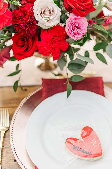  bride in a white and ivory gown with a natural waist and lace long sleeves, the groom in a burgundy velvet tuxedo with a black bow tie 