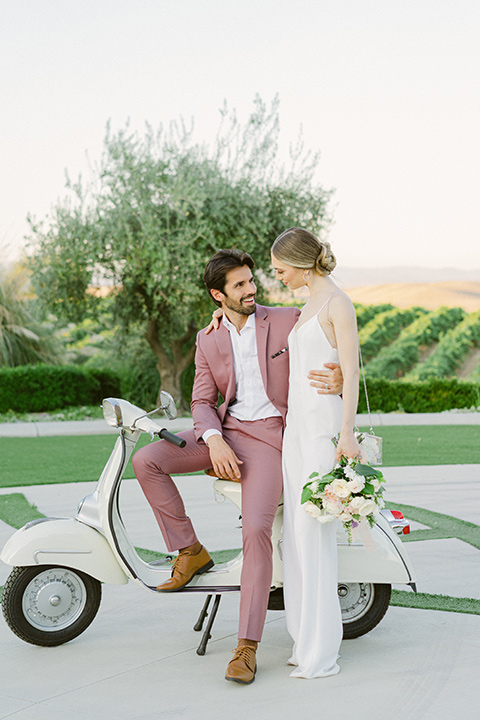  bride in a modern jumpsuit and the groom in a rose pink notch lapel tuxedo