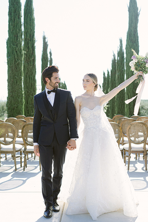  bride in a modern a line gown with a tulle skirt and the groom in a navy shawl lapel tuxedo 