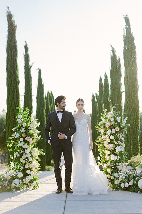  bride in a modern a line gown with a tulle skirt and the groom in a navy shawl lapel tuxedo