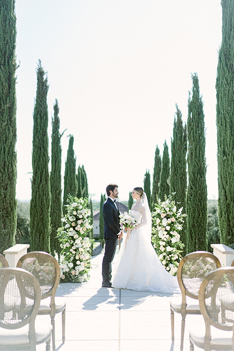  bride in a modern a line gown with a tulle skirt and the groom in a navy shawl lapel tuxedo 