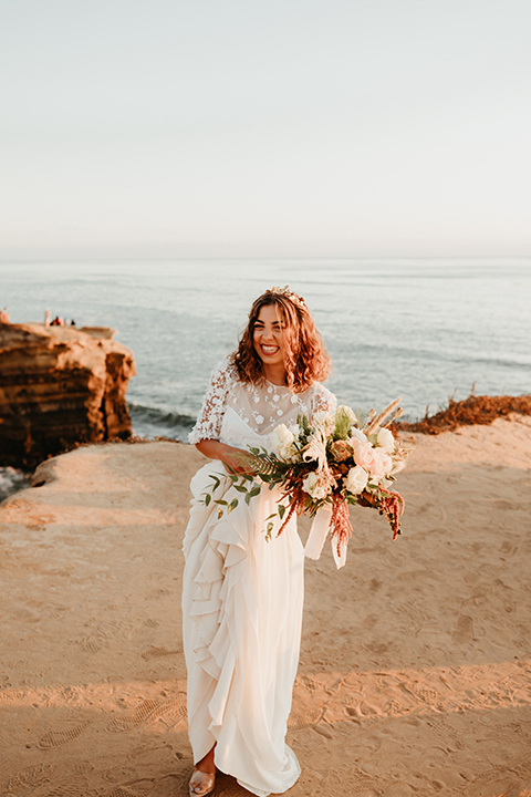  bride in a lace gown with ¾ sleeves and a gold hairpiece and the groom in a light blue suit with no tie 