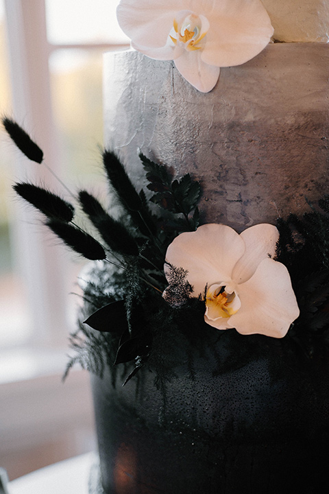  a chic black and white wedding with modern touches with the groom in a white tuxedo and the bride in a white ballgown and the bridesmaids and groomsmen in black dresses/tuxedos – a modern cake with a white to black ombre look 