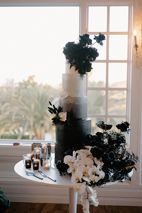  a chic black and white wedding with modern touches with the groom in a white tuxedo and the bride in a white ballgown and the bridesmaids and groomsmen in black dresses/tuxedos – a modern cake with a white to black ombre look 