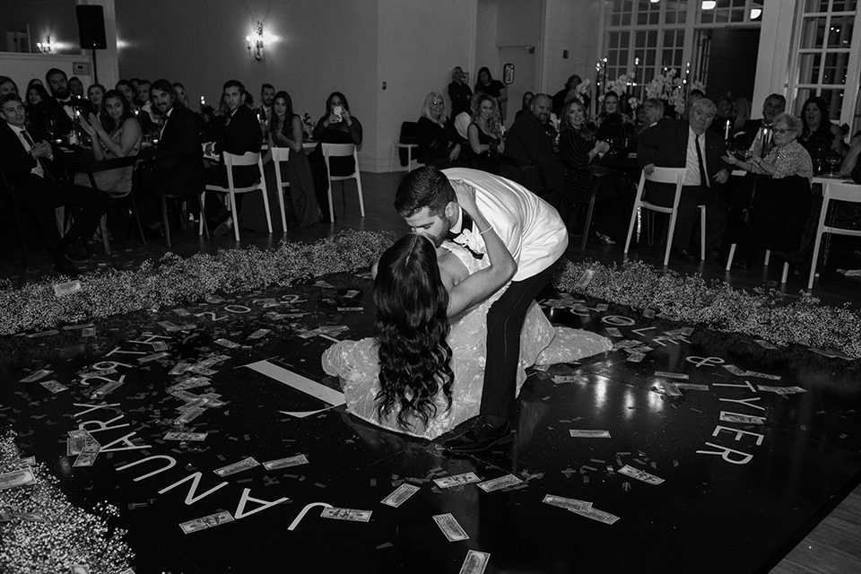  a chic black and white wedding with modern touches with the groom in a white tuxedo and the bride in a white ballgown and the bridesmaids and groomsmen in black dresses/tuxedos – first dance 