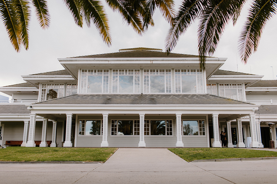  a chic black and white wedding with modern touches with the groom in a white tuxedo and the bride in a white ballgown and the bridesmaids and groomsmen in black dresses/tuxedos – venue 