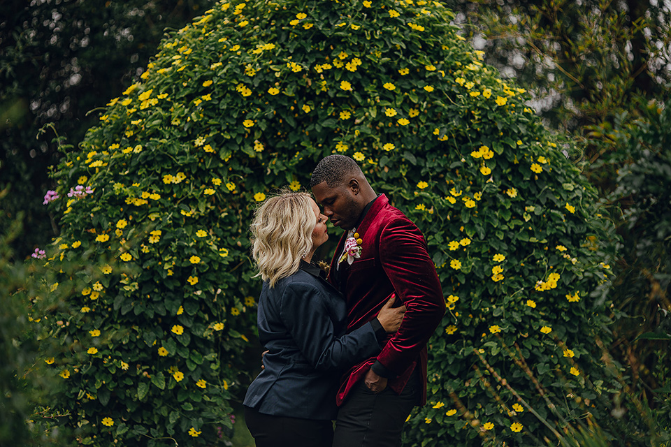  micro airbnb wedding with the bride and groom in suits – couple by headges