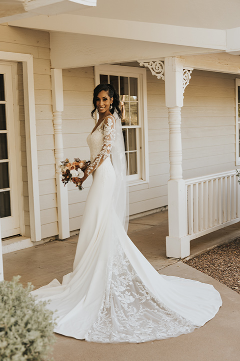  A dreamy amber toned wedding in Arizona at a wedgewood wedding venue – with the bride in a long sleeve lace gown and the bridesmaids in burnt orange dresses and the groom in a café brown suit and the groomsmen in a tan suit - bride in her wedding dress 