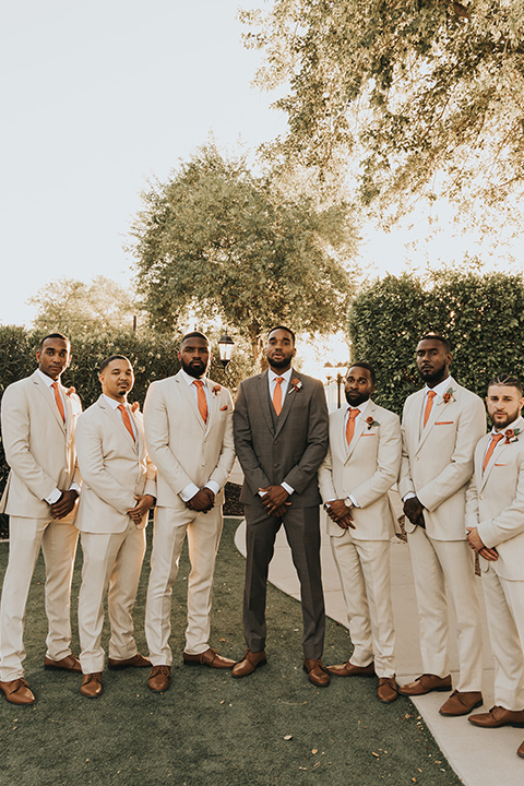  A dreamy amber toned wedding in Arizona at a wedgewood wedding venue – with the bride in a long sleeve lace gown and the bridesmaids in burnt orange dresses and the groom in a café brown suit and the groomsmen in a tan suit – groom and groomsmen 