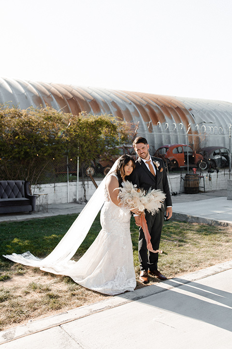  music inspired retro wedding with the bride in a lace gown and the groom in a green suit 