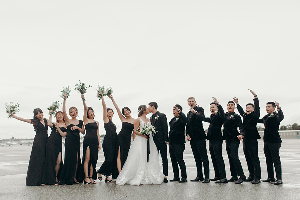  moody dark wedding at with a helicopter venue with the groom in an all-black tuxedo and the bride in a white a-line gown 