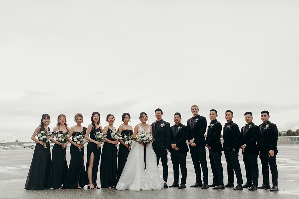  moody dark wedding at with a helicopter venue with the groom in an all-black tuxedo and the bride in a white a-line gown 