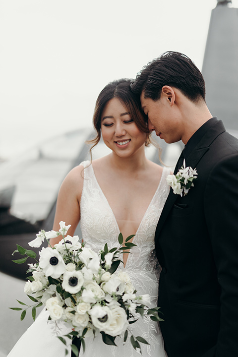  moody dark wedding at with a helicopter venue with the groom in an all-black tuxedo and the bride in a white a-line gown 