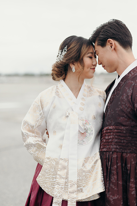  moody dark wedding at with a helicopter venue with the groom in an all-black tuxedo and the bride in a white a-line gown 