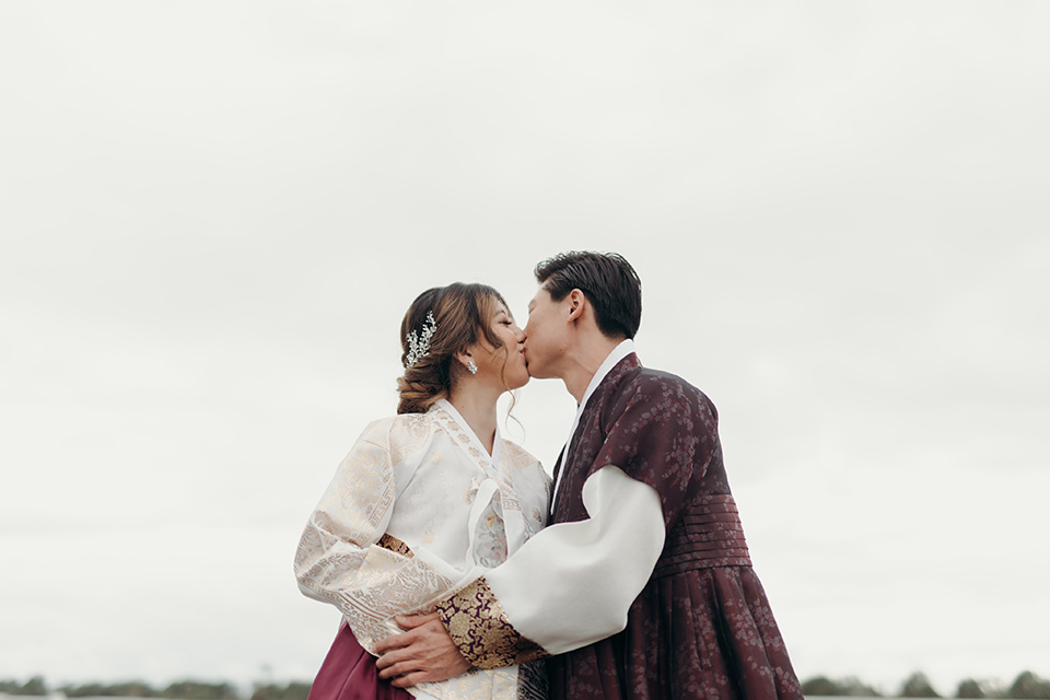  moody dark wedding at with a helicopter venue with the groom in an all-black tuxedo and the bride in a white a-line gown 