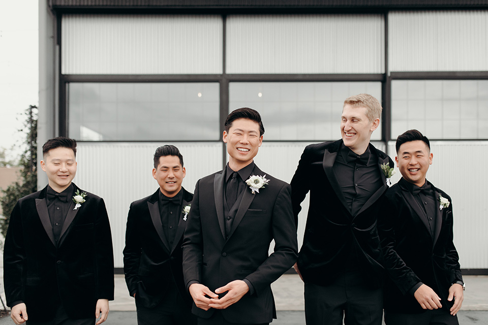  moody dark wedding at with a helicopter venue with the groom in an all-black tuxedo and the bride in a white a-line gown 