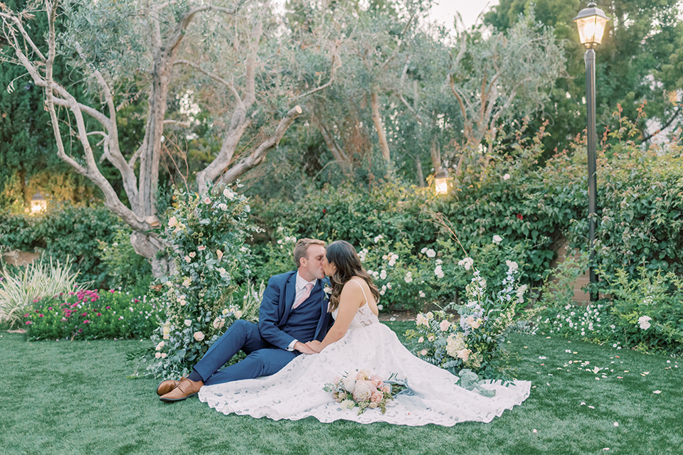  fun garden wedding with a traditional tea ceremony – couple sitting in the grass