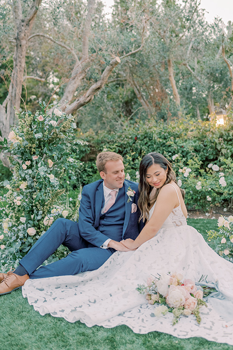  fun garden wedding with a traditional tea ceremony – couple sitting in the grass 