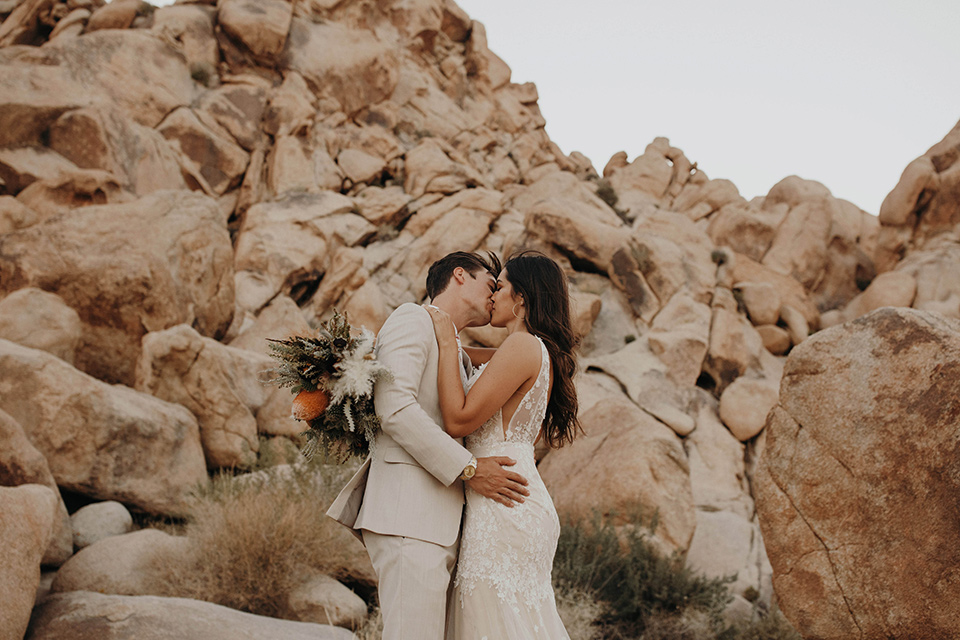  boho adventure elopement in Joshua tree, CA – couple on the boulders kissing 