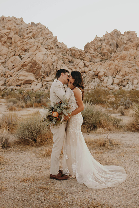  boho adventure elopement in Joshua tree, CA – couple kissing in the desert 