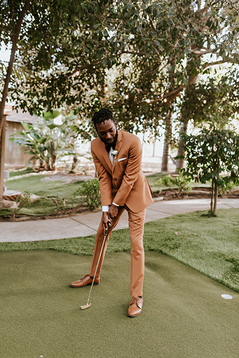  bohemian wedding with the bride in a flowing lace gown and the groom in a caramel brown suit with a green velvet bow tie- groom 