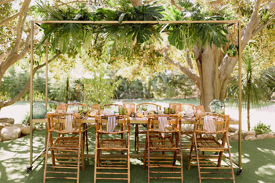  bohemian wedding with the bride in a flowing lace gown and the groom in a caramel brown suit with a green velvet bow tie- reception decor