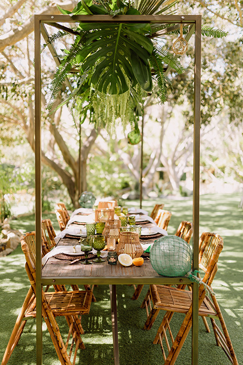  bohemian wedding with the bride in a flowing lace gown and the groom in a caramel brown suit with a green velvet bow tie- reception table