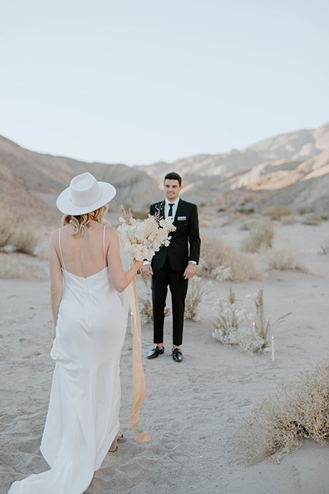  boho wedding in the desert with the groom in a black suit and the bride in a boho bridal gown 