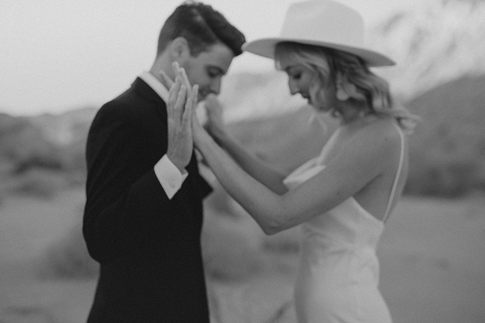  boho wedding in the desert with the groom in a black suit and the bride in a boho bridal gown 