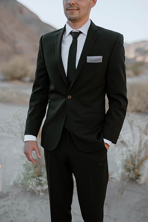  boho wedding in the desert with the groom in a black suit and the bride in a boho bridal gown 