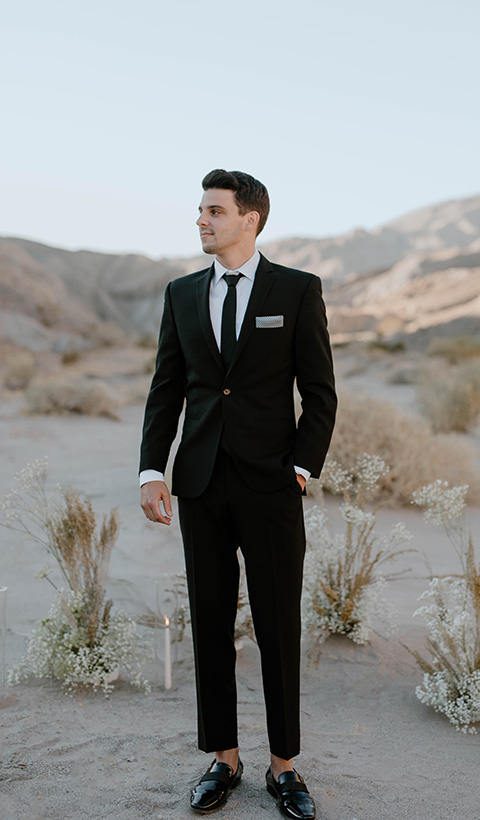  boho wedding in the desert with the groom in a black suit and the bride in a boho bridal gown 