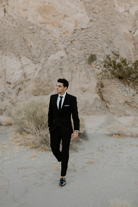  boho wedding in the desert with the groom in a black suit and the bride in a boho bridal gown 