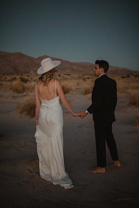  boho wedding in the desert with the groom in a black suit and the bride in a boho bridal gown 