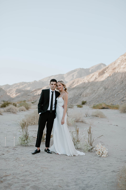  boho wedding in the desert with the groom in a black suit and the bride in a boho bridal gown 