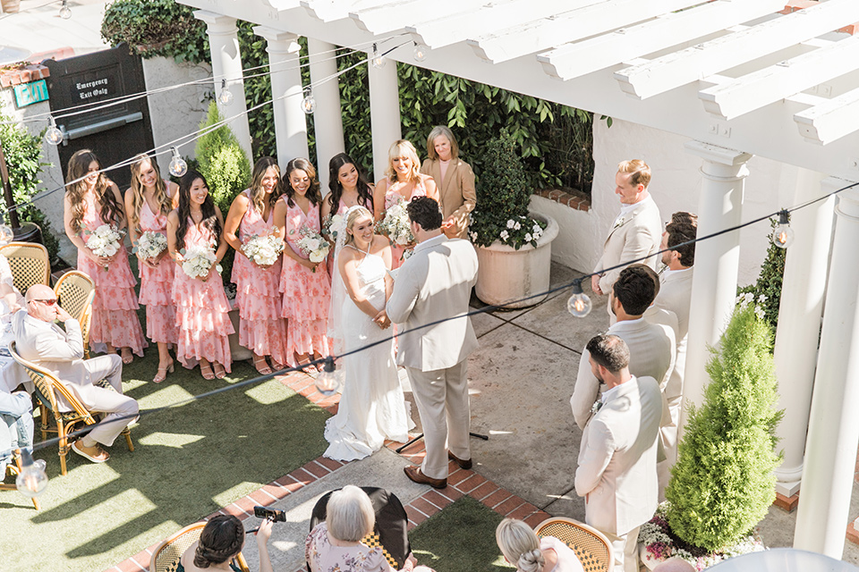  tan and pink garden wedding with floral bridesmaid dresses and the groom and groomsmen in tan suits – ceremony from above 