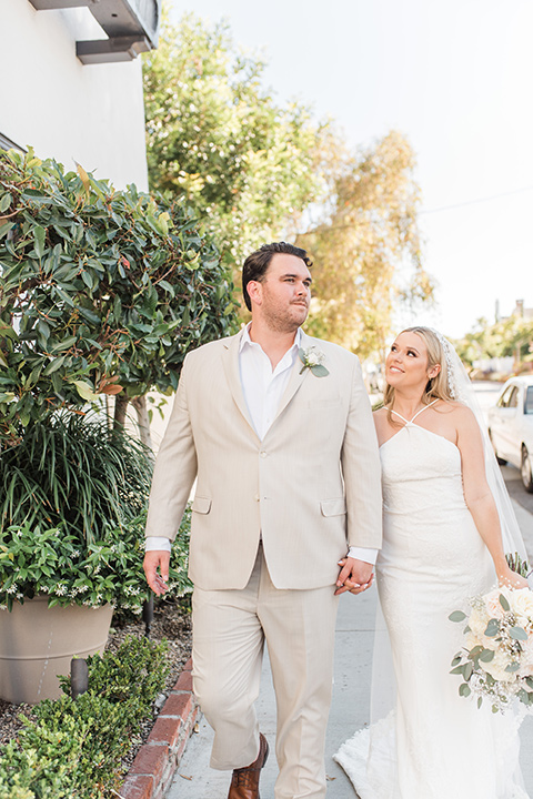  tan and pink garden wedding with floral bridesmaid dresses and the groom and groomsmen in tan suits – walking 