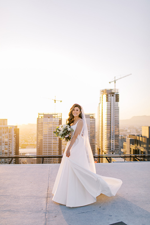  A city wedding with the guys in burgundy and black tuxedos and the bridesmaids in blush dresses- bride in her wedding dress