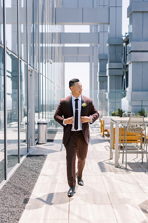  A city wedding with the guys in burgundy and black tuxedos and the bridesmaids in blush dresses- groom in a burgundy tuxedo 