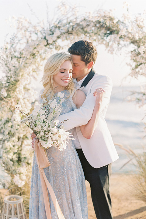  luxe black and white wedding on the beach in san diego – bride in a light blue gown and the groom in a white and black shawl tuxedo