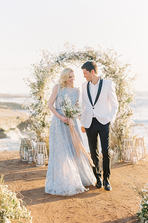  luxe black and white wedding on the beach in san diego – bride in a light blue gown and the groom in a white and black shawl tuxedo 