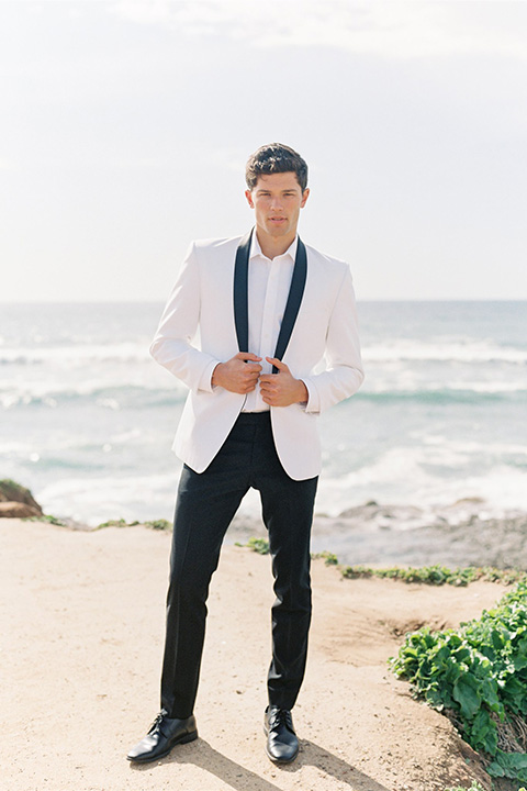  luxe black and white wedding on the beach in san diego – bride in a light blue gown and the groom in a white and black shawl tuxedo