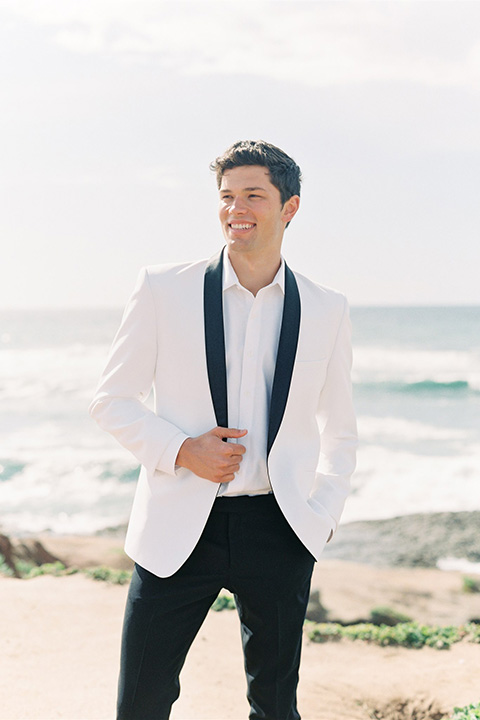  luxe black and white wedding on the beach in san diego – bride in a light blue gown and the groom in a white and black shawl tuxedo 