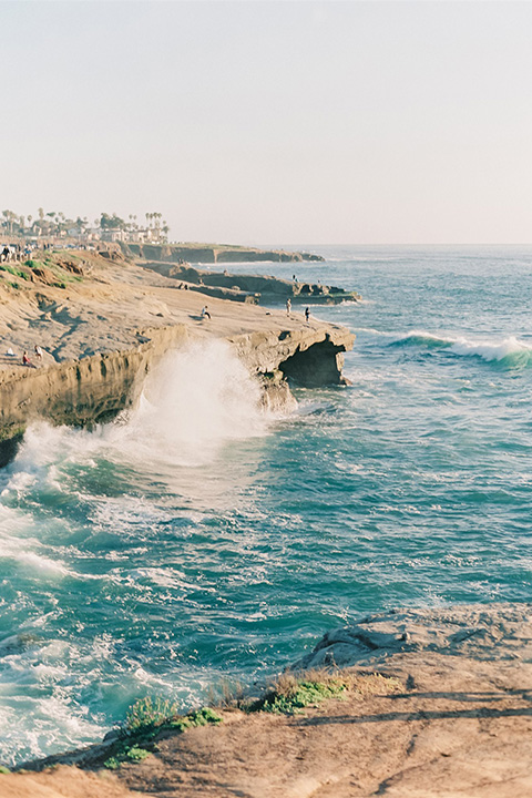  luxe black and white wedding on the beach in san diego – bride in a light blue gown and the groom in a white and black shawl tuxedo