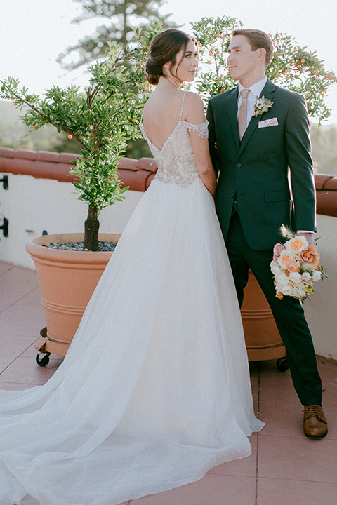  hotel wedding with garden flowers and the groom in a green notch lapel suit 