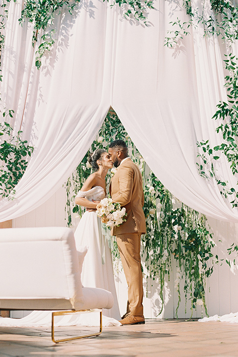  blush and ivory wedding with the groom in a caramel brown suit and the bride in a lace gown 